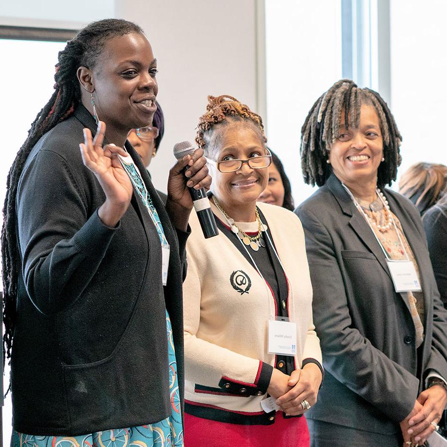 women of color speaking at a conference